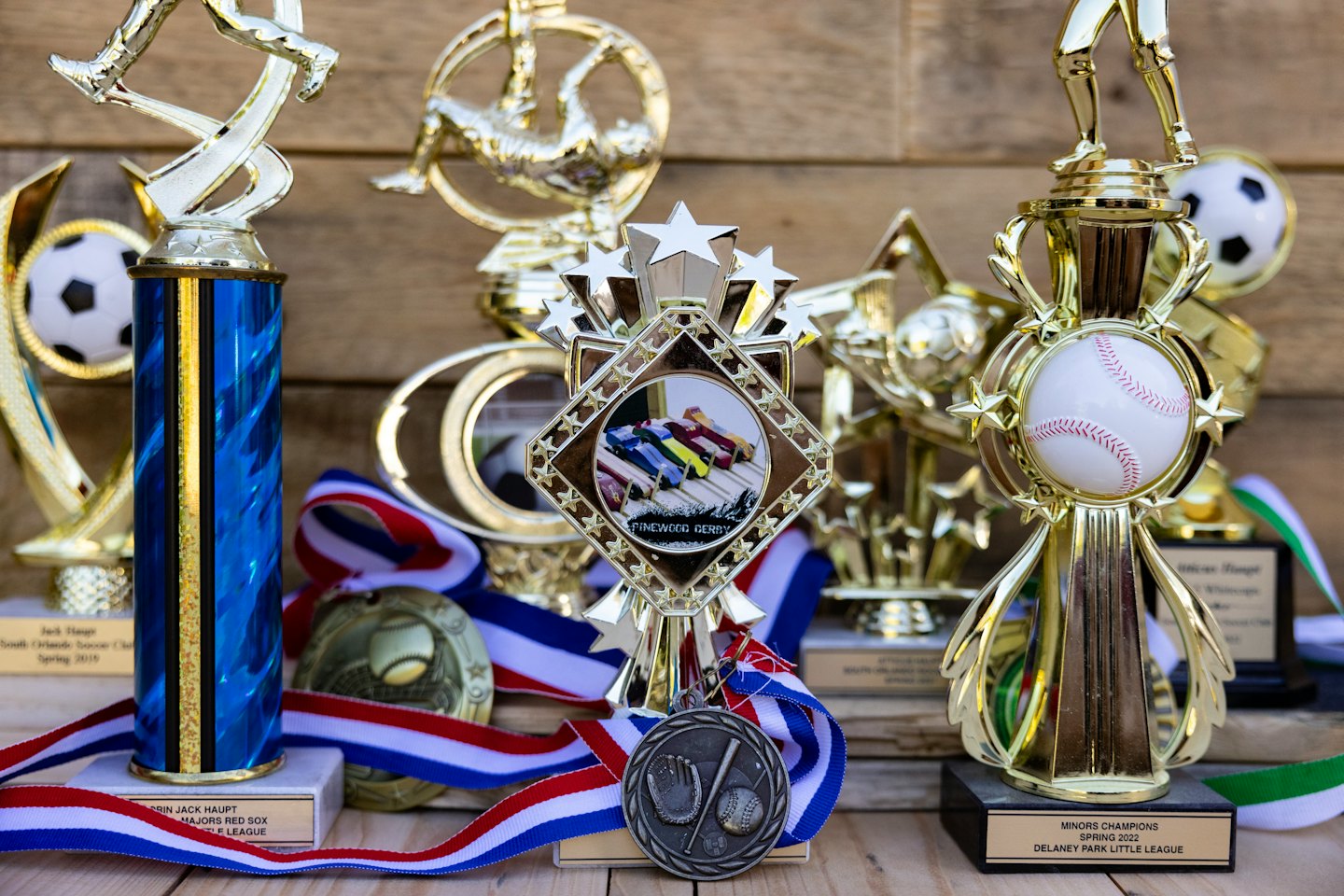 Eine Sammlung von goldenen und silbernen Sportpokalen und Medaillen.